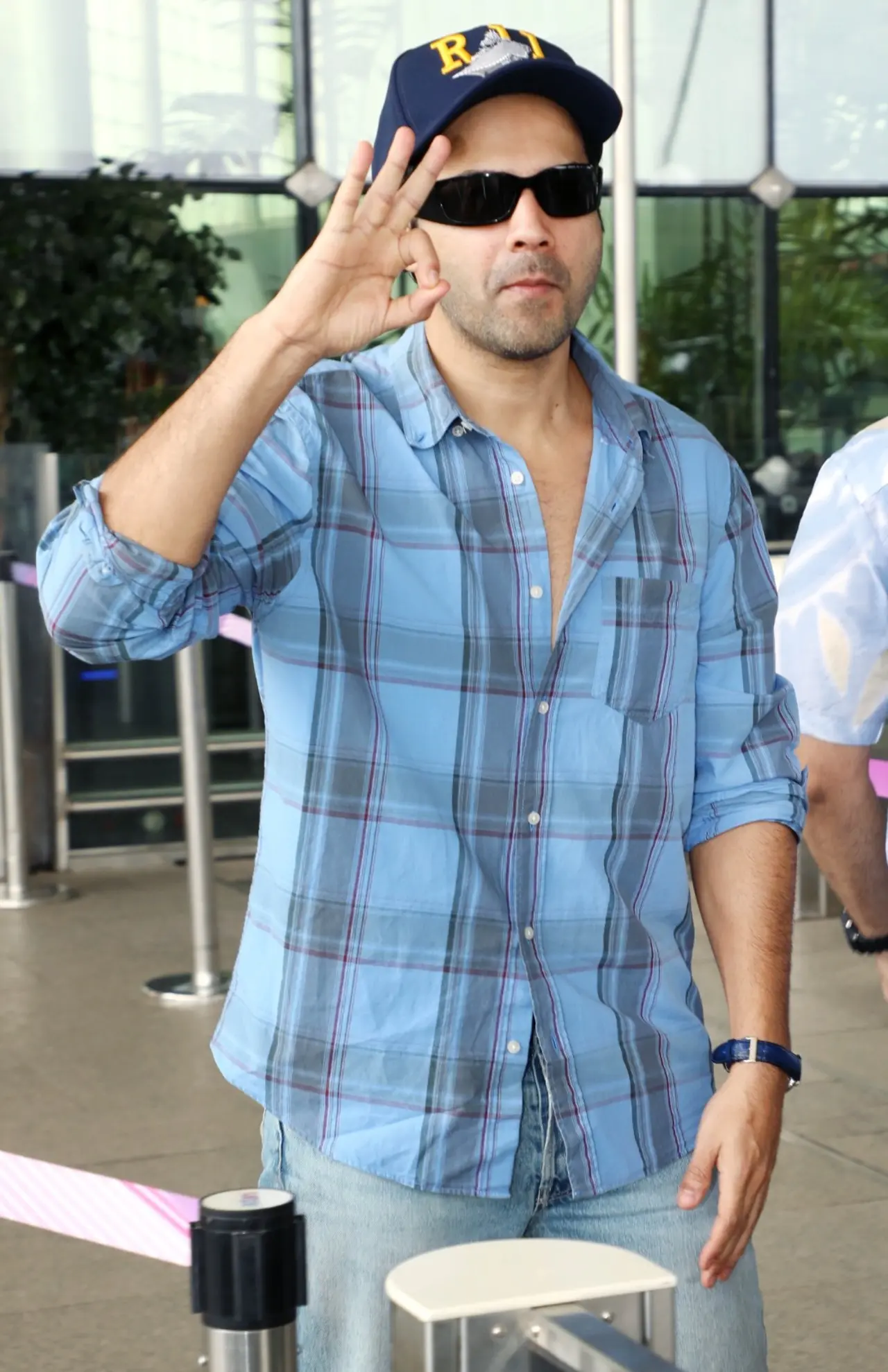 Varun Dhawan went for a breezy, travel-ready look in a blue and grey shirt layered loosely over a casual top, paired with classic light-wash denim. Varun Dhawan went for a breezy, travel-ready look in a blue and grey shirt layered loosely over a casual top, paired with classic light-wash denim.